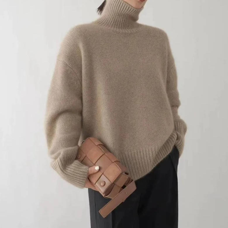 Marigold turtleneck jumper in beige, front view with woven clutch