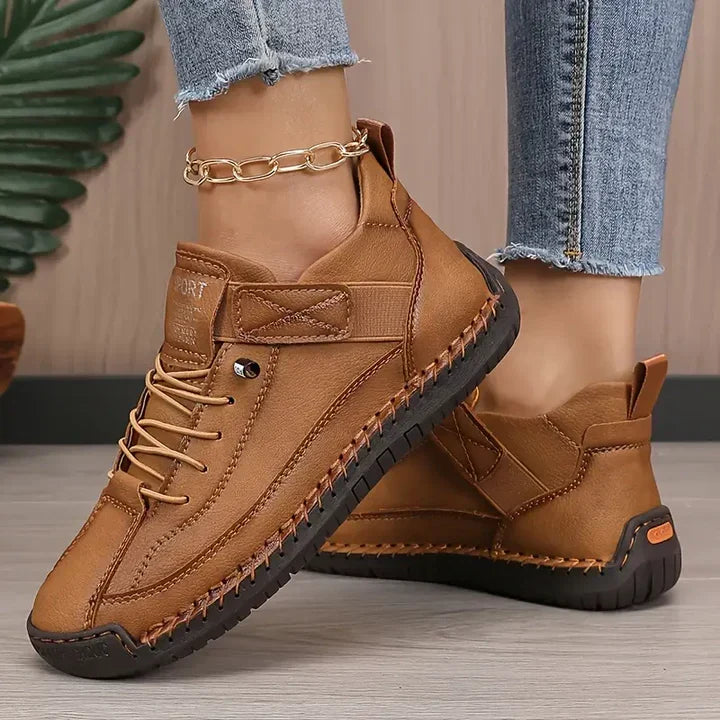 Clementine green orthopaedic sneakers with hand-stitched detail, pair on floor