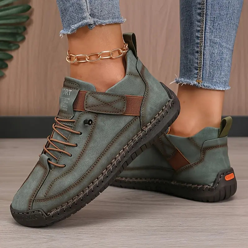 Clementine green orthopaedic sneakers with hand-stitched detail, pair on floor