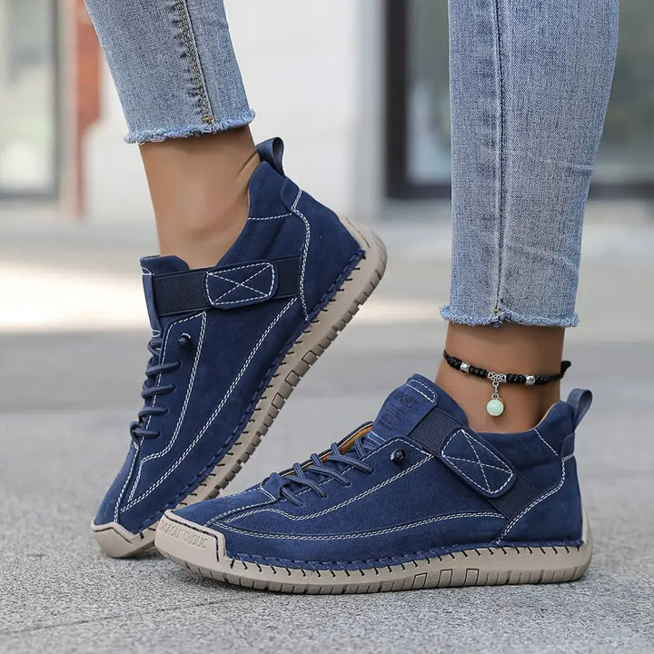 Clementine green orthopaedic sneakers with hand-stitched detail, pair on floor