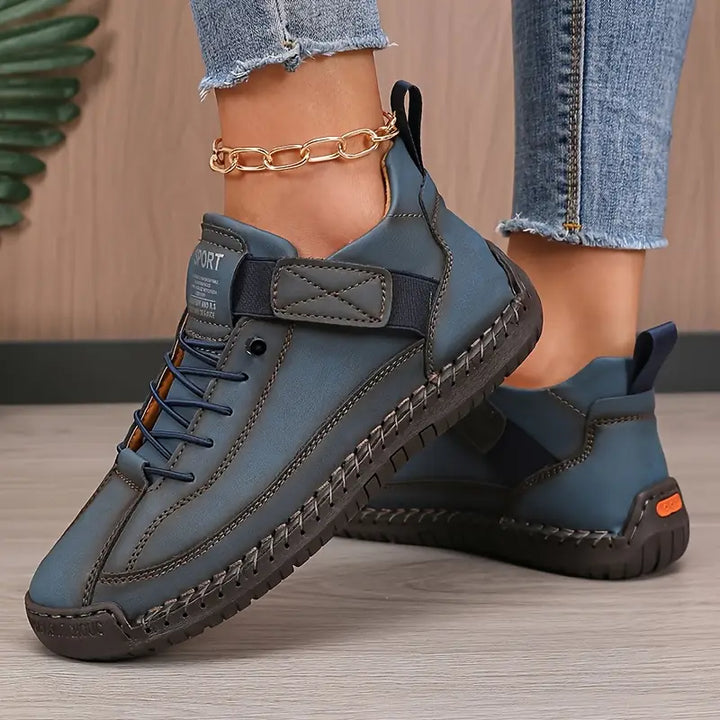 Clementine green orthopaedic sneakers with hand-stitched detail, pair on floor