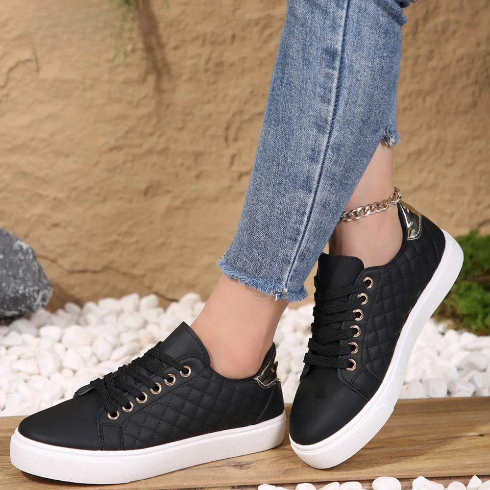 Imogen black quilted lace-up platform trainers, side view on model