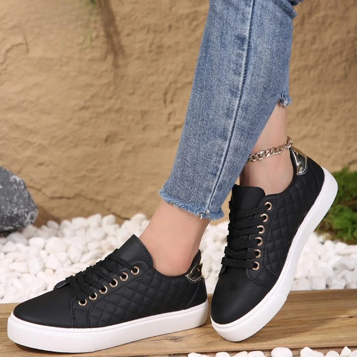 Imogen black quilted lace-up platform trainers, side view on model