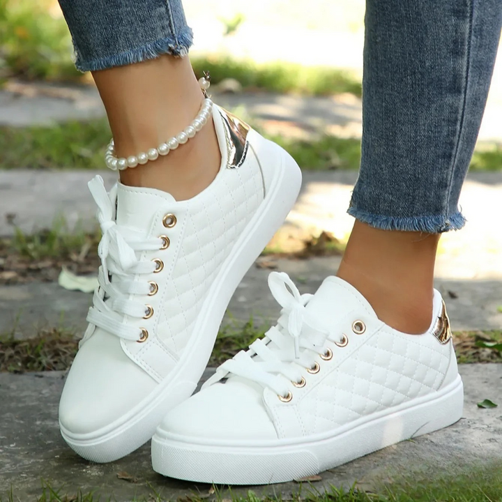 Imogen white quilted platform trainers with metallic heel detail, close-up